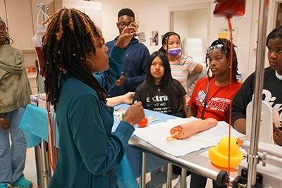 Middle School students watching a demonstration by healthcare instructor.