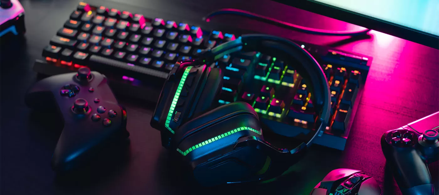 gamer work space concept, top view a gaming gear, mouse, keyboard, joystick, headset with rgb color on black table background.