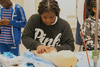 Middle school student interacting with a lab demonstration.