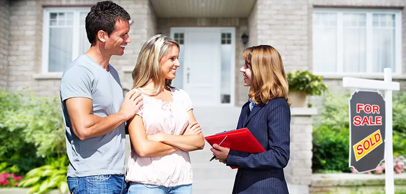 Real Estate agent woman with clients near new house.